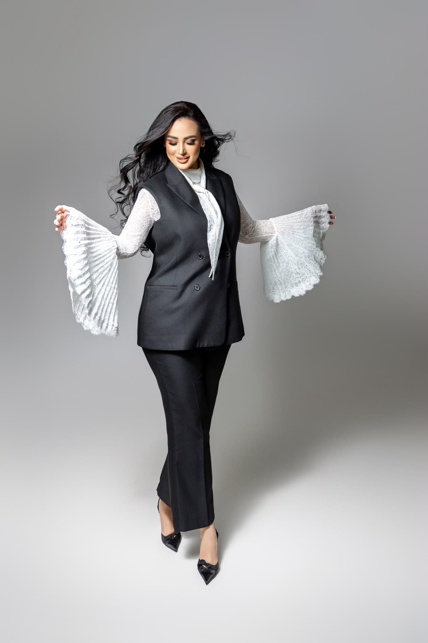 Ghada Arbi with flowing hair and white lace sleeves